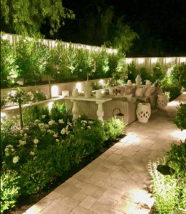 Backyard garden patio with pathway lighting at night