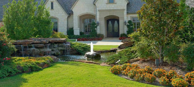 Front yard with pond, fountain, and vibrant garden landscaping