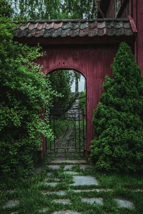 Garden pathway leading through an arched wooden gate